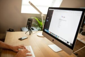 Desktop iMac showing Google search results on a clean wooden desk for homepage SEO planning