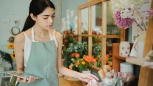 Website design Baulkham Hills florist reviewing customer orders in a local shop